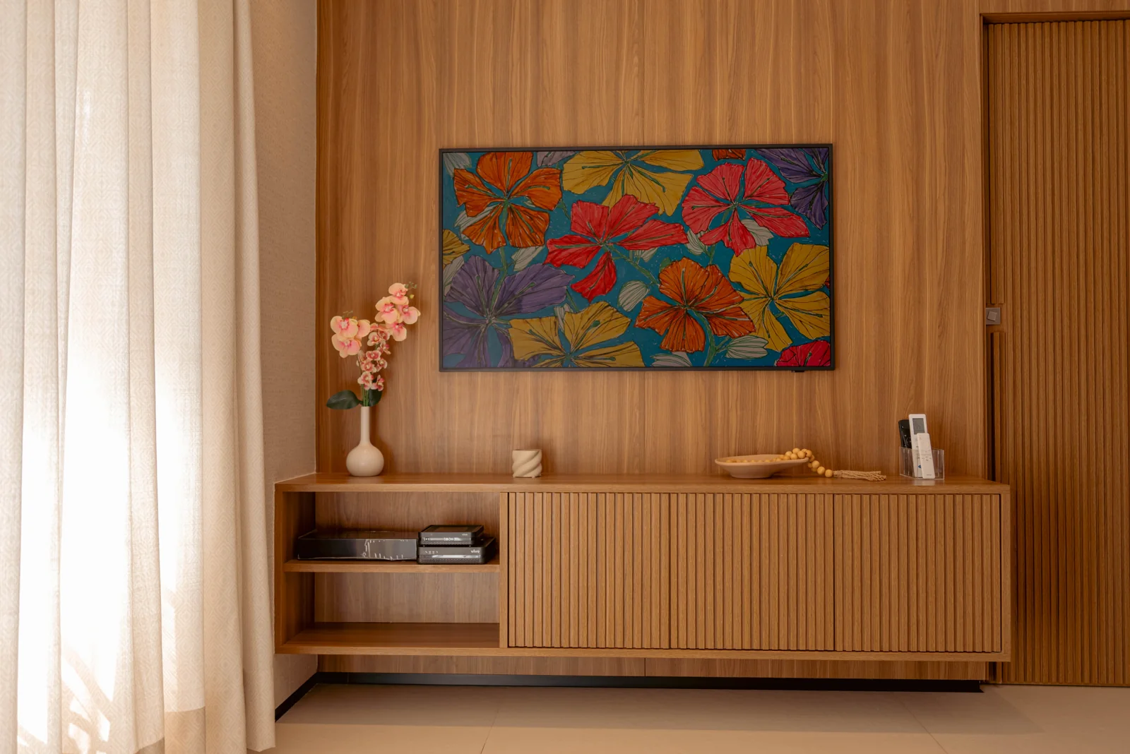 Painel de madeira da sala com quadro colorido e aparador