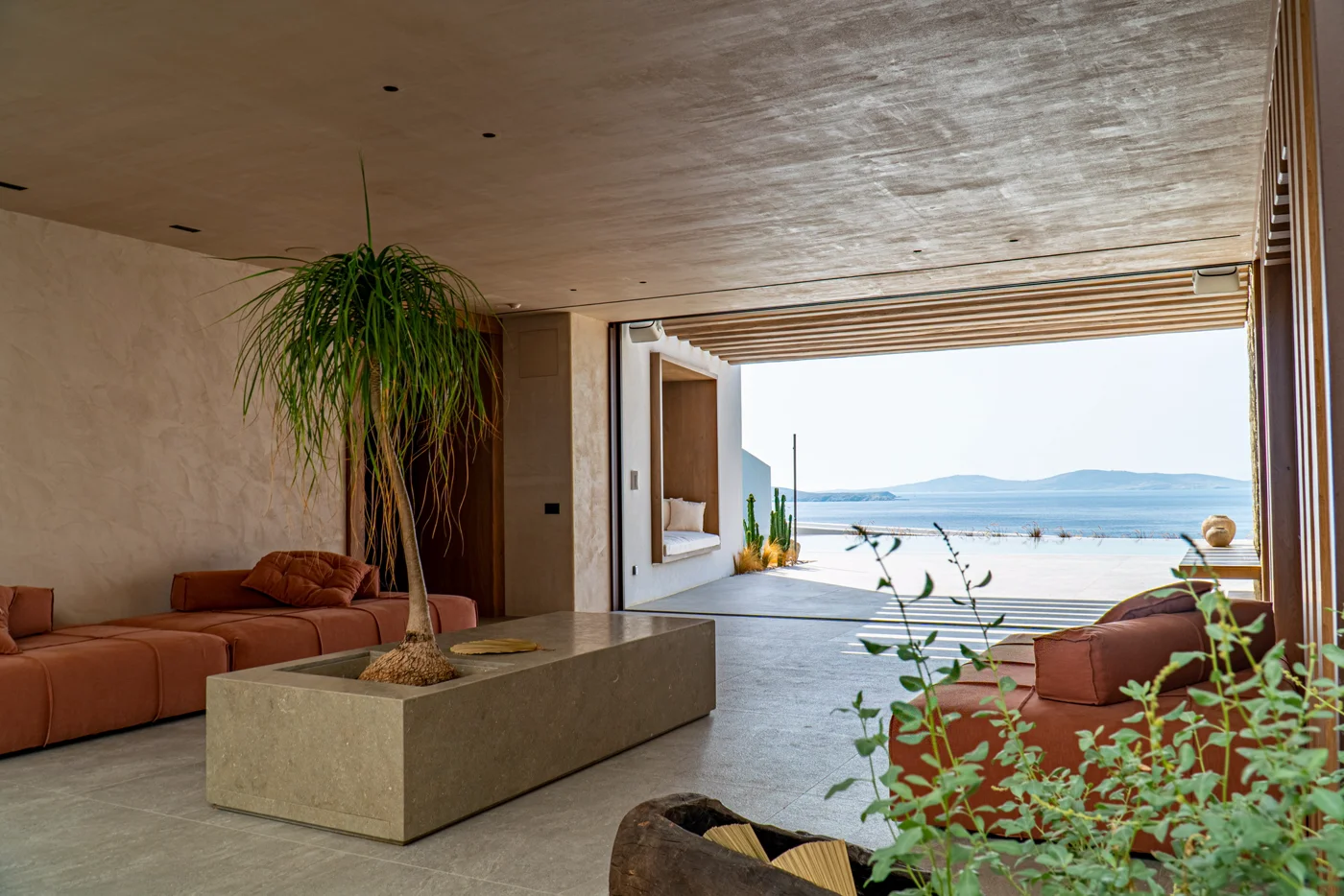 A sala de estar aberta para a piscina e o mar Egeu