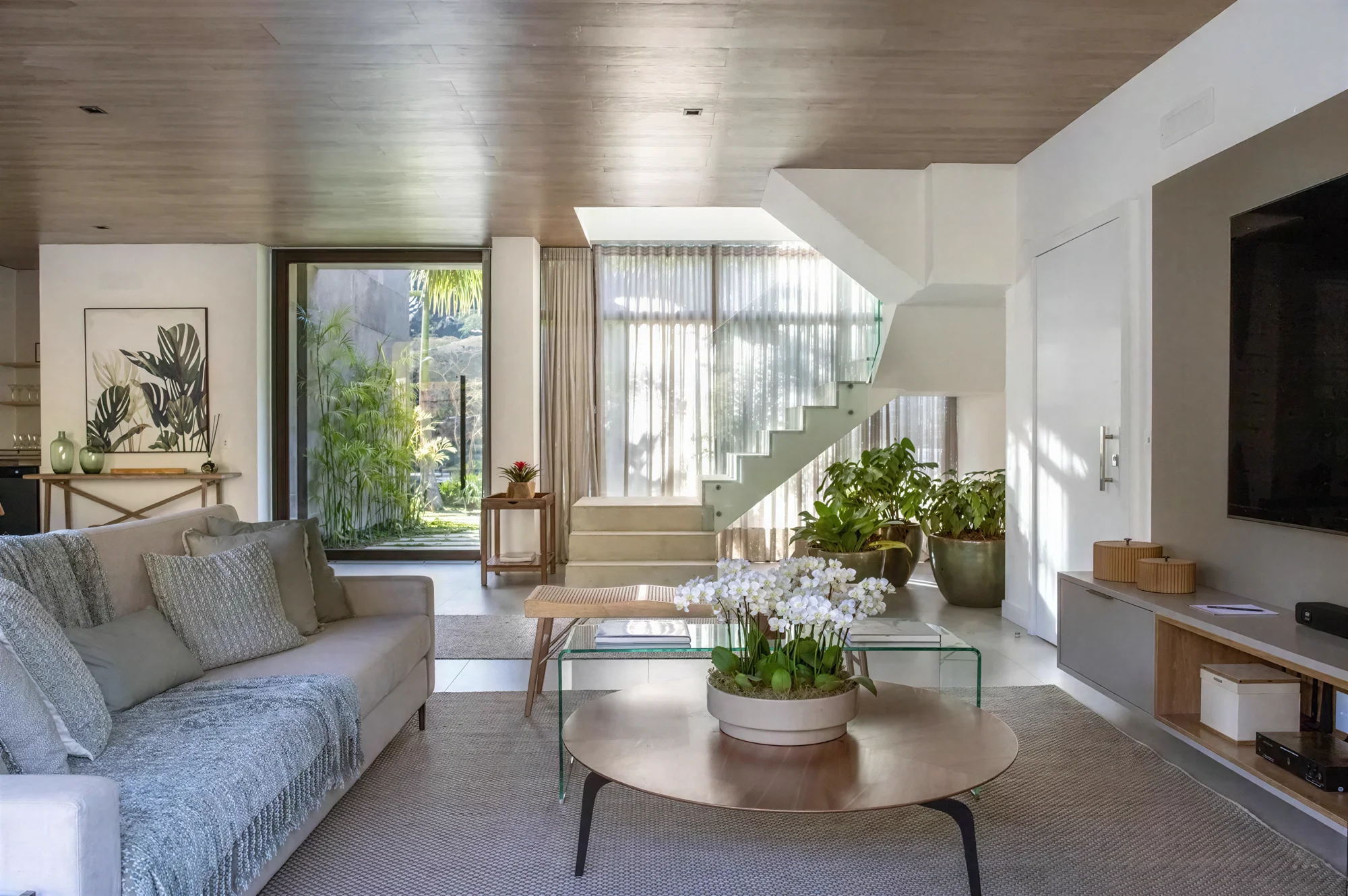 Sala de estar da casa, com escada e vista para o jardim